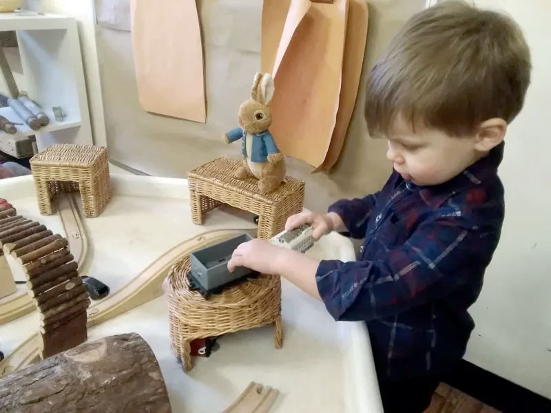 A child playing with a wooden train set