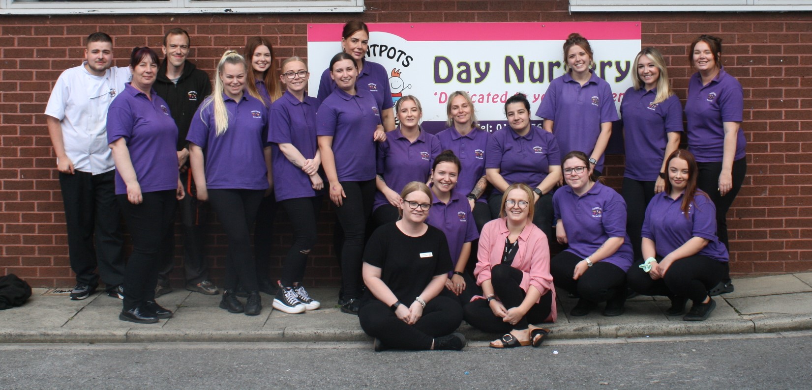 The Newall Green team outside the Paintpots Day Nursery sign